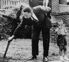 Мартин Лутър Кинг и неговият син премахват изгорен кръст от предния си двор. 1960 г.